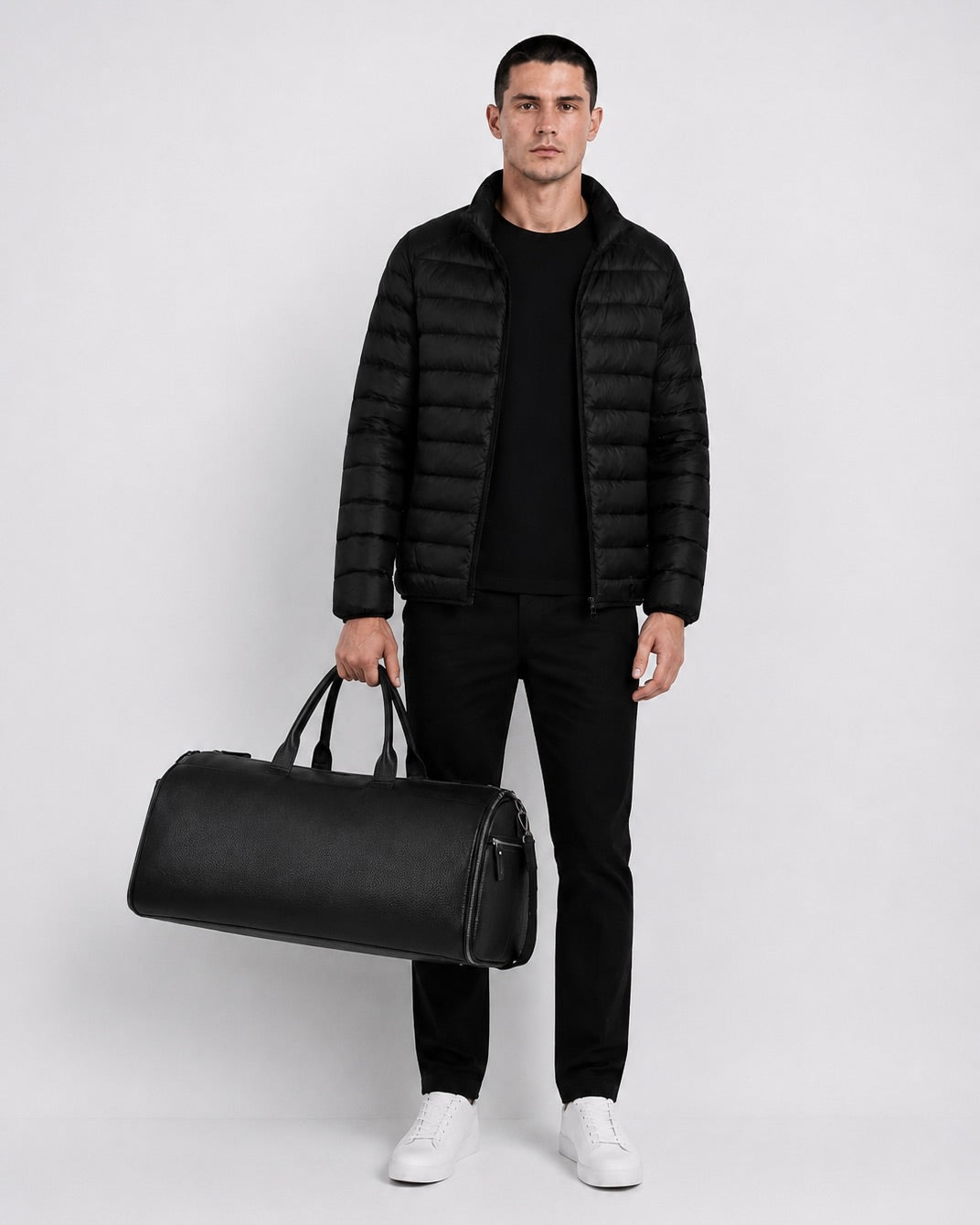 Man carrying the black leather C-01 travel duffel by hand