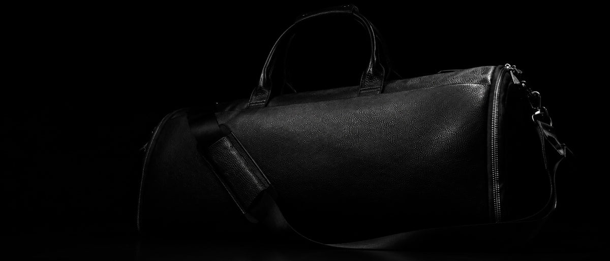 Bolso de viaje de cuero C-01 en una composición editorial.