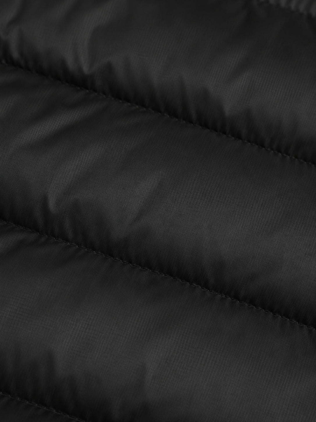 Detalle del acolchado de la casaca de plumas negra J-01.
