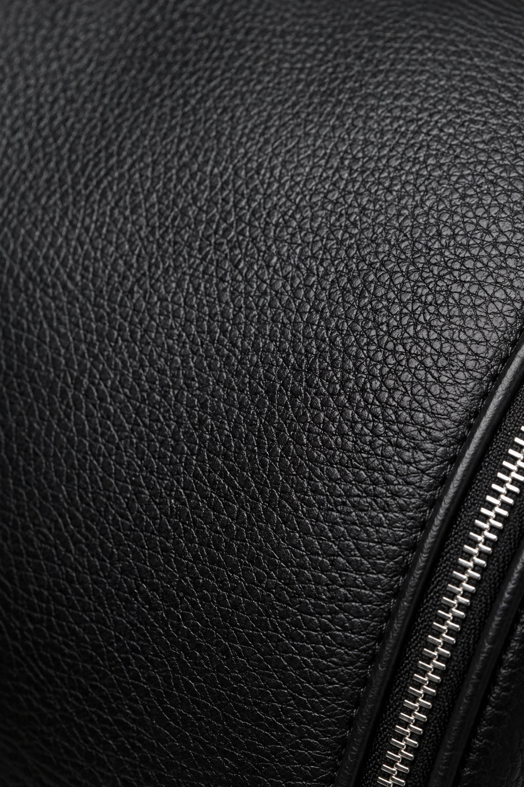Detalle del cuero full-grain negro y cierre metálico del bolso C-01.