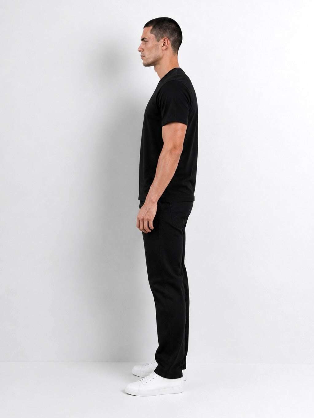 Modelo usando el polo negro de algodón Pima T-01, vista lateral.