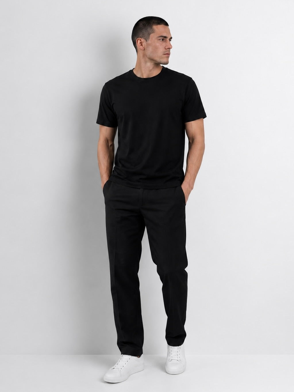 Modelo usando el polo negro T-01 Essential Pima, vista frontal.