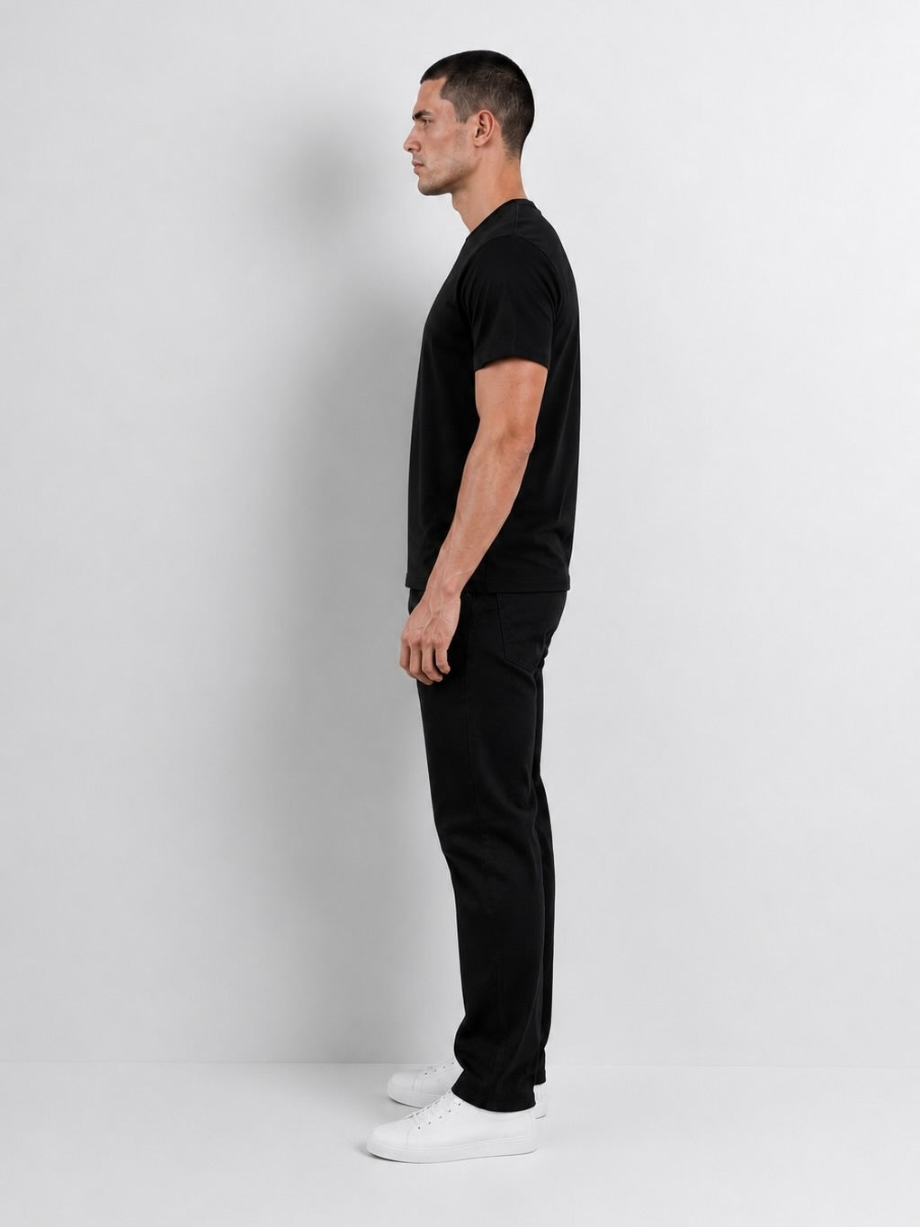 Perfil lateral del polo negro de algodón pima para hombre.