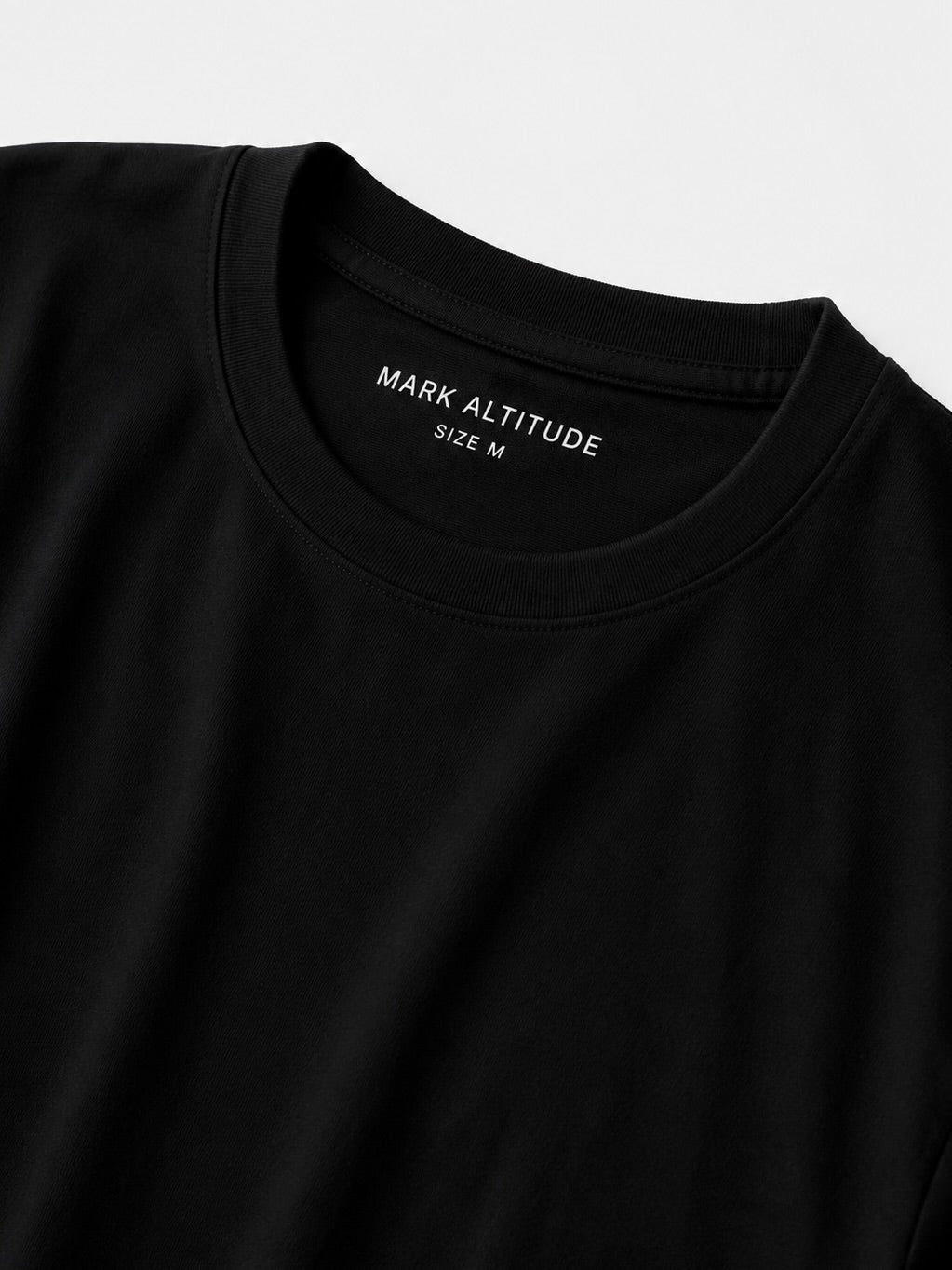 Detalle del cuello redondo del polo negro T-01 Essential Pima.