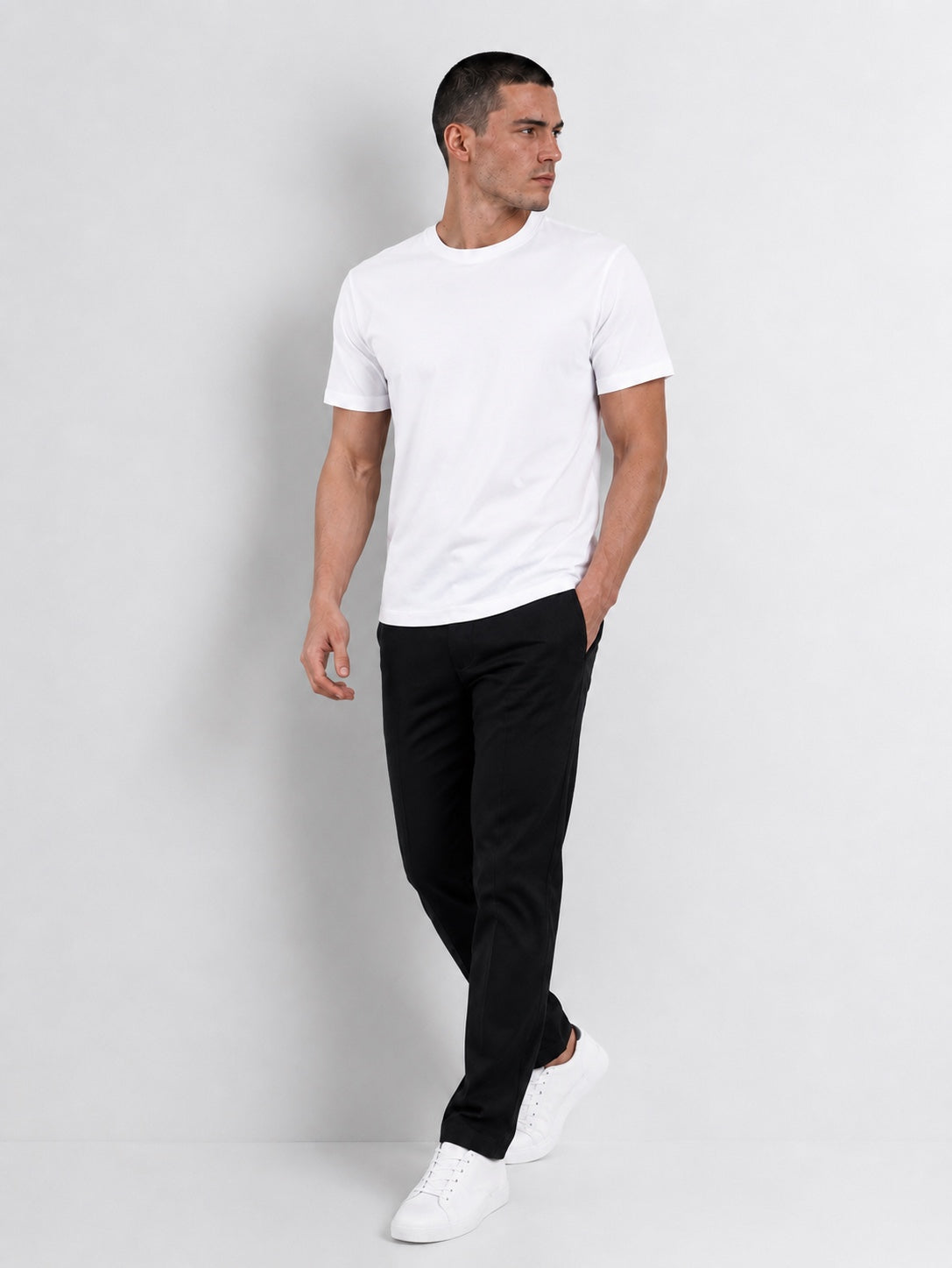 Modelo caminando con el polo blanco T-01 Essential Pima.