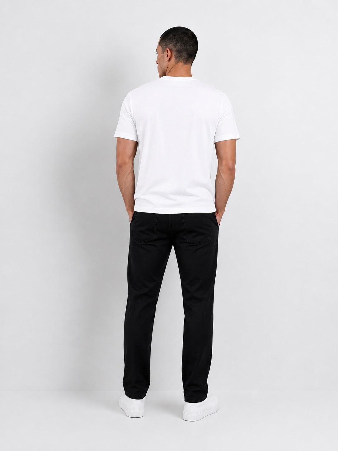 Modelo usando el polo blanco T-01 Essential Pima, vista posterior.